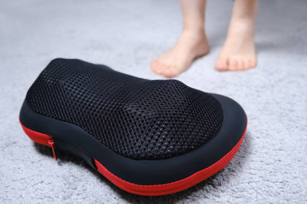 istock Women's legs and electric automatic massager, foot massage with a massage pillow. 1356560314