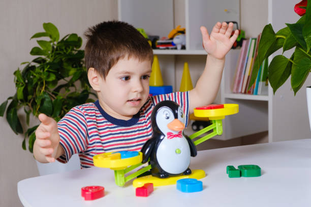 istock A preschool boy learns numbers, weighs numbers on a penguin scale 1356560366