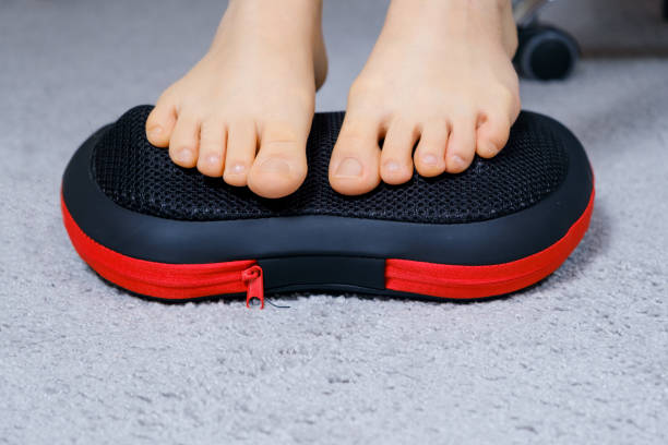 istock Women's feet on a massage pillow, relieving leg fatigue after a day's work. 1356560381