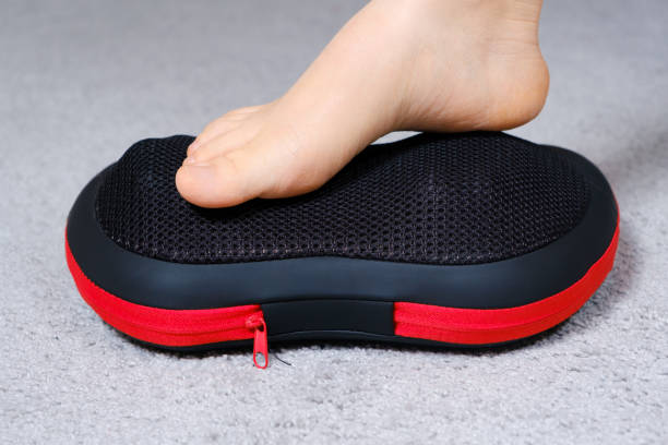 istock Women's feet on a massage pillow, relieving leg fatigue after a day's work. 1356560393