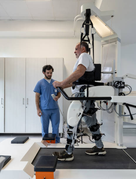 homme âgé marchant avec un exosquelette tout en faisant de la physiothérapie - centre de désintoxication photos et images de collection