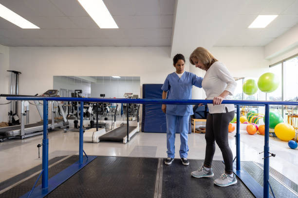 istock Senior woman in physical therapy walking on the parallel bars 1356562129