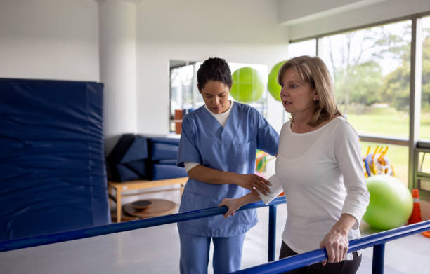 istock Woman in physiotherapy walking on the parallel bars 1356562156
