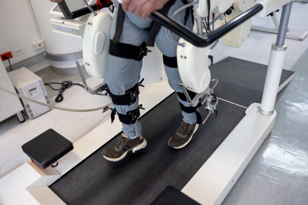 Close-up on a man using a powered exoskeleton during his physical therapy Close-up on a man using a powered exoskeleton during his physical therapy at a rehab center powered exoskeleton photos stock pictures, royalty-free photos & images