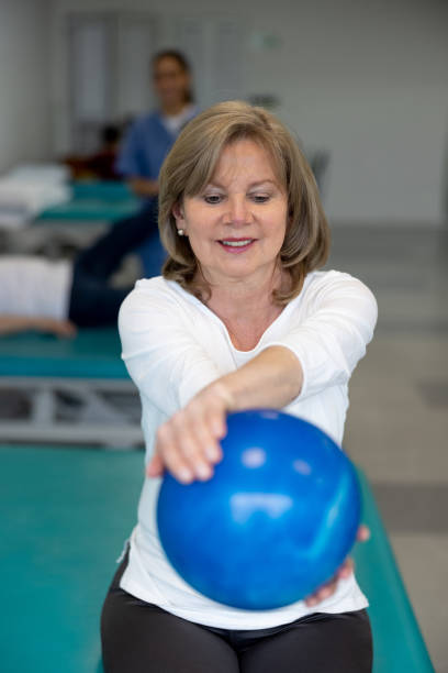 istock Senior woman using a fitness ball while doing physical therapy 1356562180