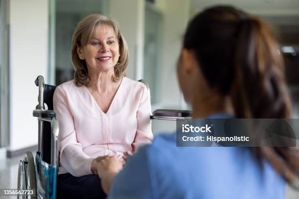 Disabled Patient In A Wheelchair Talking To A Nurse At The Hospital Stock Photo - Download Image Now