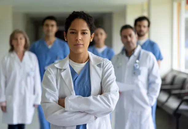 Latin American female doctor leading a team of healthcare workers at the hospital - medicine concepts