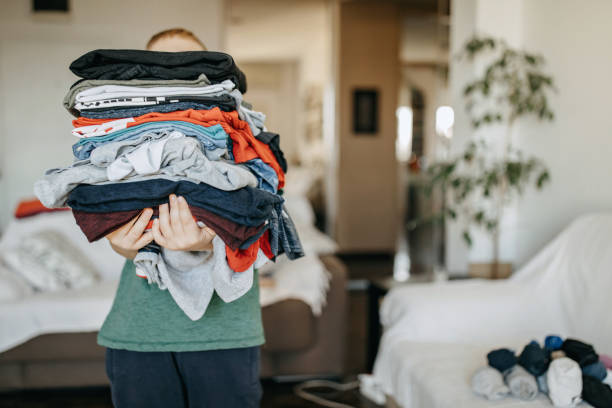 Boy folding clean laundry stock photo