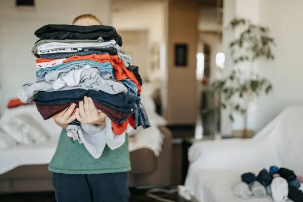 Boy folding clean laundry