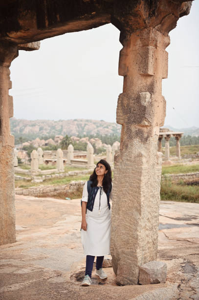 istock Woman standing at a pillar inside old ruins at Hampi, Karnataka 1356564593