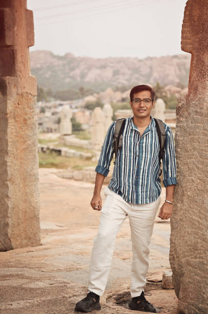 istock Man standing at a pillar inside old ruins at Hampi, Karnataka 1356564635