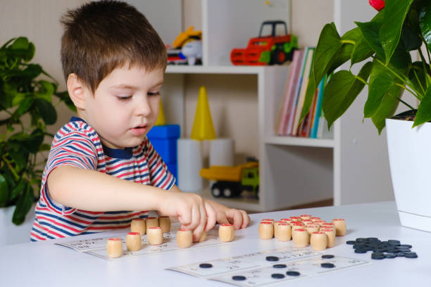 istock A 4-year-old boy plays loto, studies numbers using a board game. 1356564645