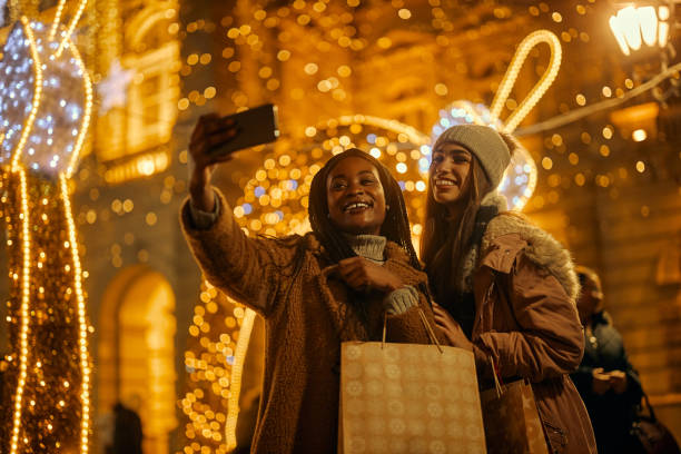 istock Two beautiful girls taking selfie while enjoying Christmas shopping 1356568416