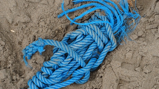 Blue rope on beach sand. Use to tying the ship on sea.