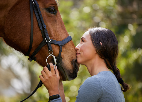 Young female horse rider bonding with her horse. Bangkok, Thailand. May 2017