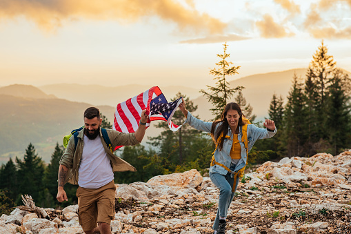 Couple on a mountain top holding American flag