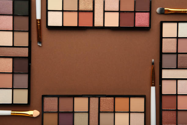 istock Professional makeup palette with brushes on brown background. Make up cosmetics 1356569923