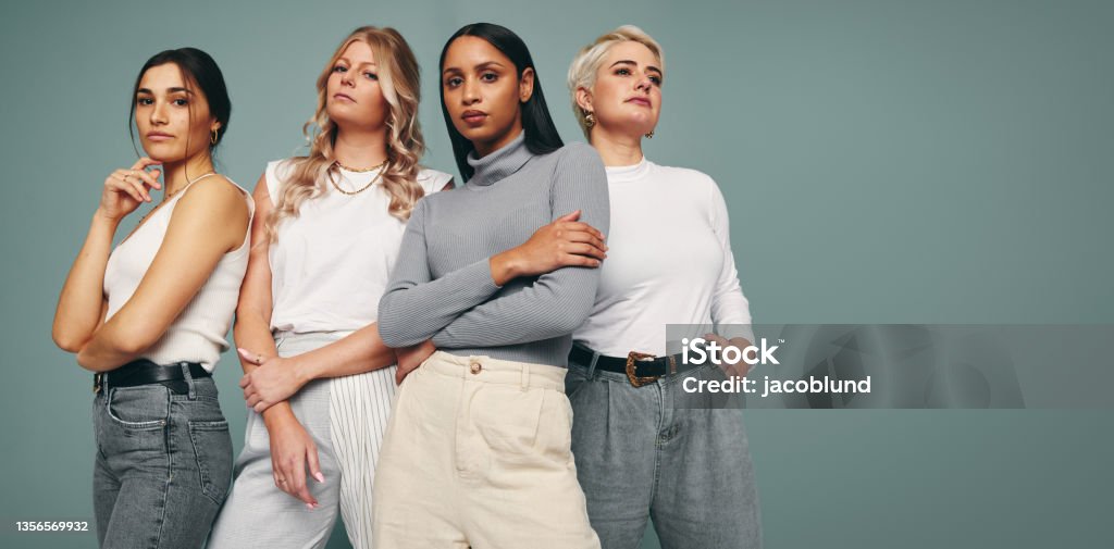 Style and confidence Style and confidence. Diverse group of empowered women standing together against a studio background. Self-confident female friends standing in a studio. Fashion Stock Photo