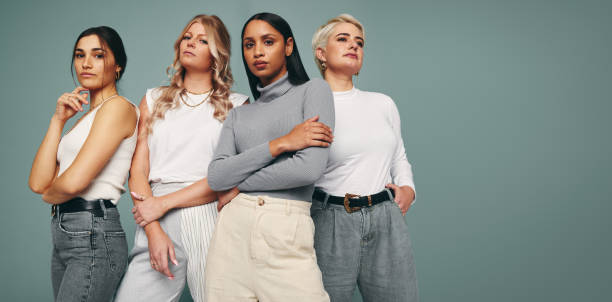 Style and confidence Style and confidence. Diverse group of empowered women standing together against a studio background. Self-confident female friends standing in a studio. fashion industry stock pictures, royalty-free photos & images