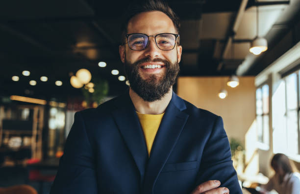 istock Cheerful businessman smiling at the camera in a co-working space 1356570967