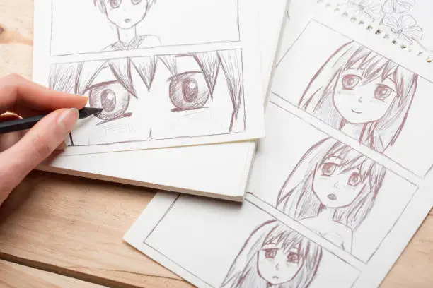Photo of Artist drawing an anime comic book in a studio.