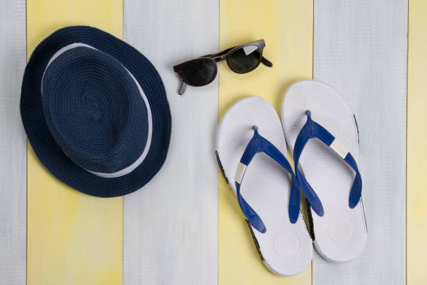 istock on a gray-yellow surface, beach flip-flops, sunglasses and a hat 1356572429