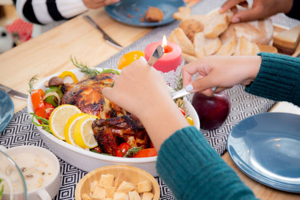 gros plan des mains d’enfants utilisant un couteau tranchant de la viande de dinde rôtie sur des plats pour manger à la maison le jour de la veille de thanksgiving, célébration de noël avec dîner en famille, nouvel an, festif et vacances. - new years day new years eve new year ethnic photos et images de collection