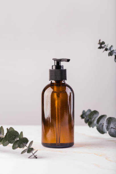 Amber glass cosmetic bottle with eucalyptus leaves. Natural no plastic concept stock photo