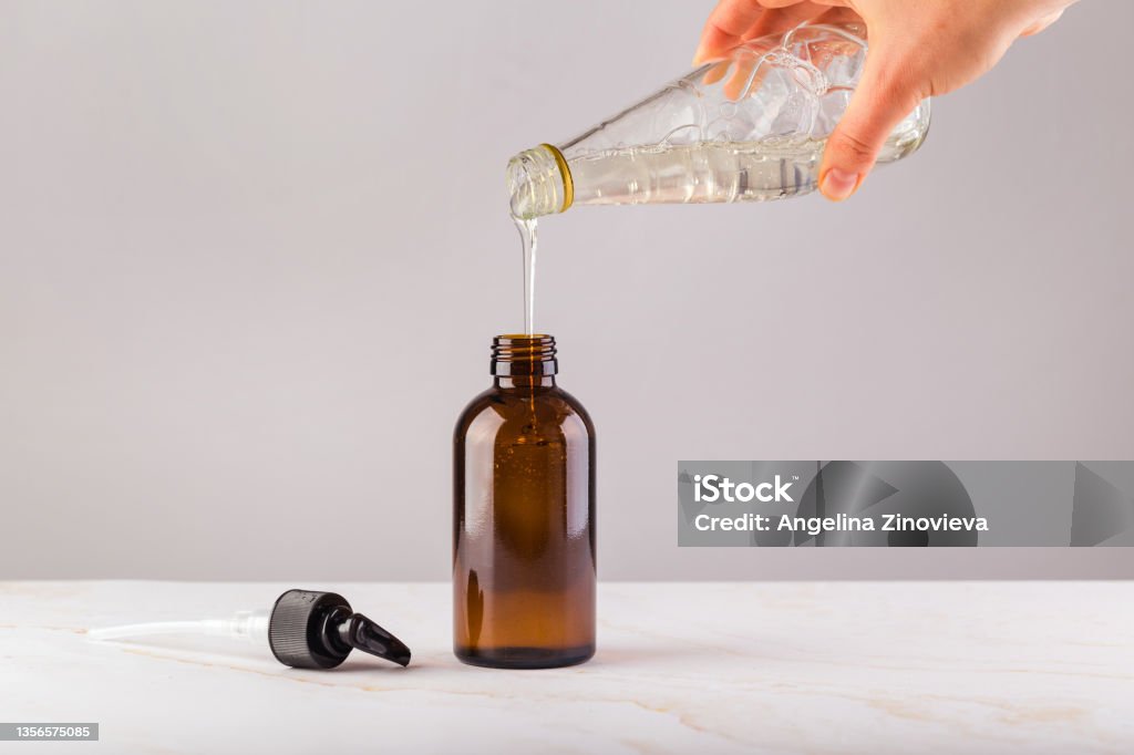 woman hand refilling shower gel into a reusable glass bottle in zero waste store concept woman hand refilling shower gel into a reusable glass bottle in zero waste store concept. High quality photo Refill Stock Photo
