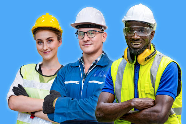 istock group workers engineering standing with confident with blue working suite dress and safety helmet in front of blue background. Concept of smart industry worker operating. 1356576466