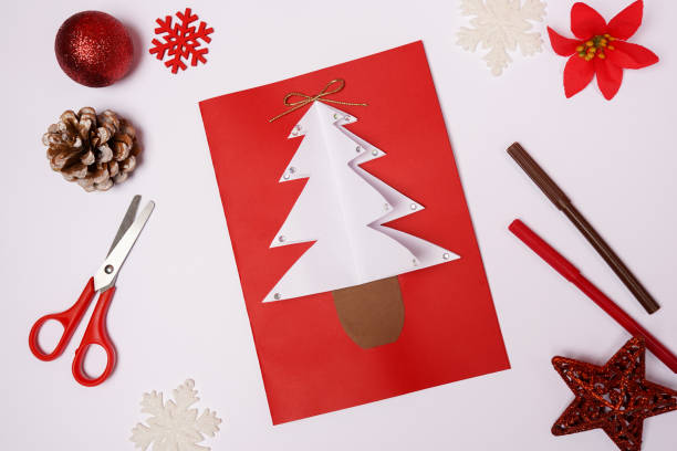 istock DIY Christmas card with fir-tree from colored paper on white background 1356577145