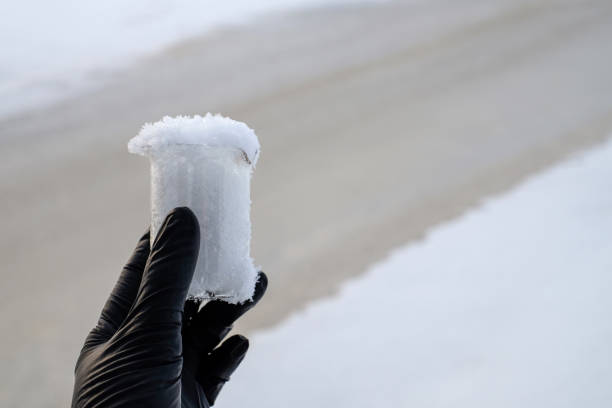 Hand in black glove holding snow sample from the sea, water diversion, ecology concept. Copy space