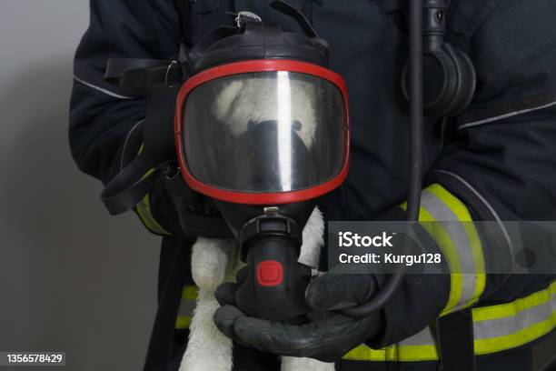 A Firefighter Put A Breathing Mask On A Childs Toy A Rescued Teddy Bear Stock Photo - Download Image Now