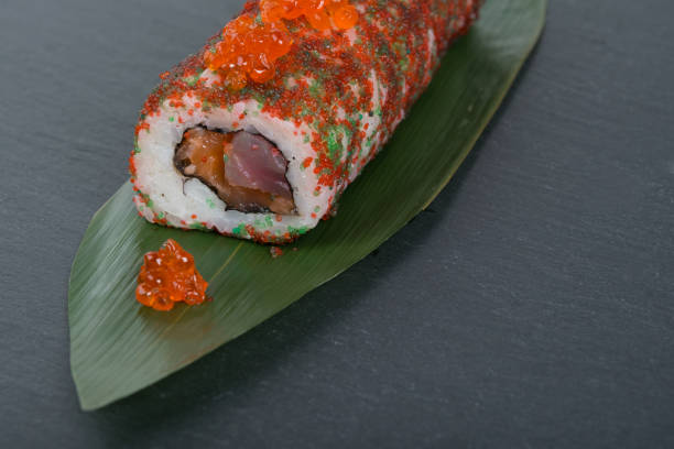 istock close-up, sliced rolls with caviar, fish, vegetables, tuna, as a background, on a green bamboo leaf 1356578743