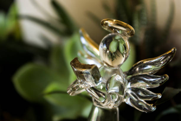 A grouping of succulents reflecting within a small glass angel, as part of a summer Christmas decoration