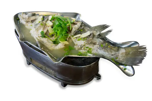 Photo of Top view of Steamed Seabass with Lime and Chillies in fish shape plate.