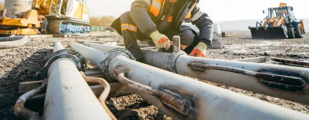 Photo of Workers stack iron pipes for pouring concrete before building a bridge