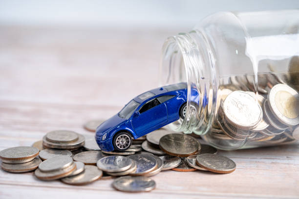 Car on coins background; Car loan, Finance, saving money, insurance and leasing time concepts. stock photo