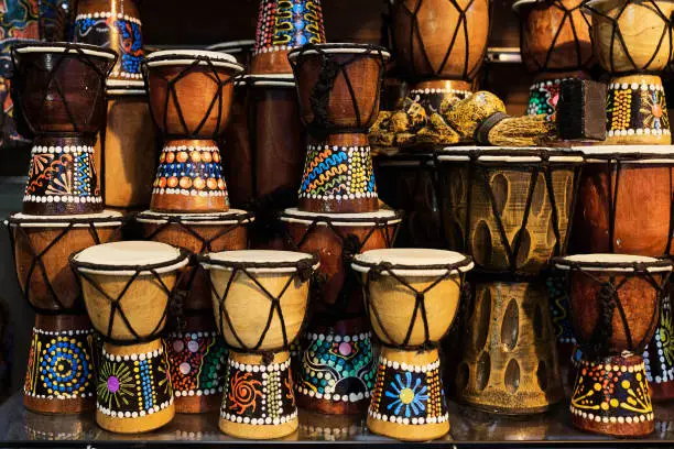 Many small African drums in an oriental souvenir shop. Various kinds of percussion instruments made of wood