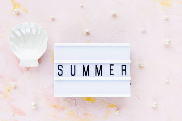 istock Word SUMMER on pink with white seashell decoration background 1356583025