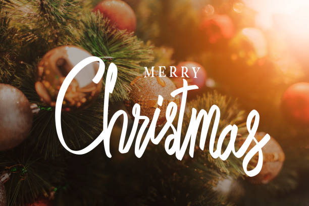 istock merry Christmas, vintage handwriting on decorated Christmas tree 1356583044