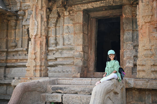 istock Girl sitting on stone in an ancient stone temple 1356584817