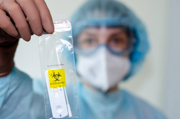istock Medical laboratory assistant holding positive COVID-19 rapid test. 1356585908