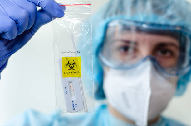 Medical laboratory assistant holding positive COVID-19 rapid test. stock photo