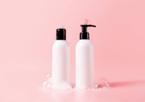 Shampoo and hair conditioner bottle with soapy bubbles. Beauty hair care cosmetic packaging mockup stock photo