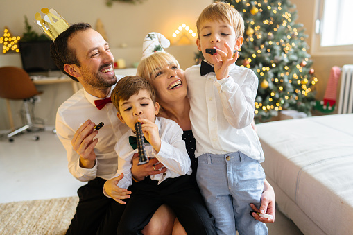 Photo of a family with two children celebrating Christmas and New Year holidays together at home.