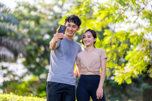 istock Two young Asian lovers making a selfie on smart phone 1356592197
