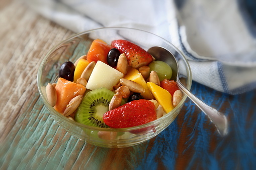 fruit salad with baru nuts and honey in glass bowl