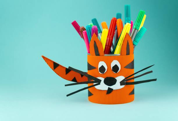 istock Step 9. Step-by-step instructions on how to make a stand for stationery from a tin can. Tiger made of paper and cardboard, scissors and glue. A fun DIY craft for children. Do it yourself paper tiger 1356594138