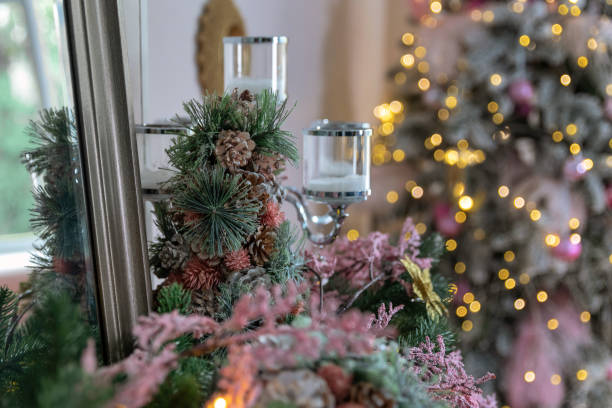 istock Christmastime Interior. Artificial pine branches, cones and candlesticks. Blurred Christmas light on background. Selective focus. 1356594336